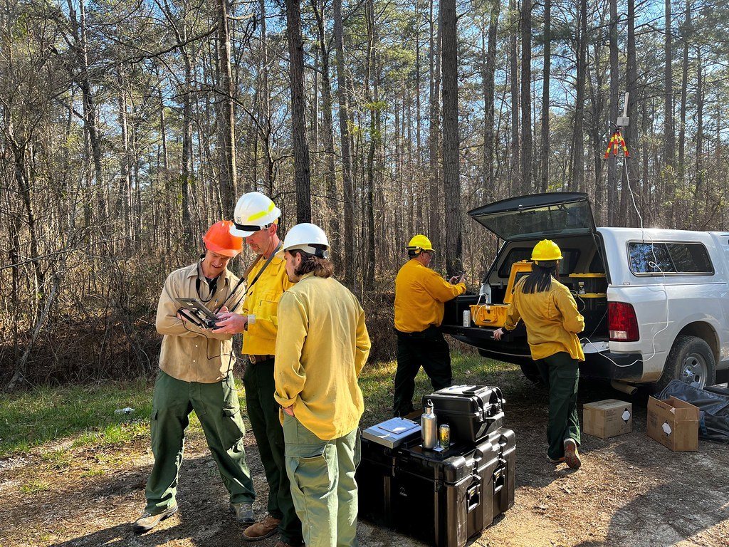 Crew gathered at a truck for drone training in the field